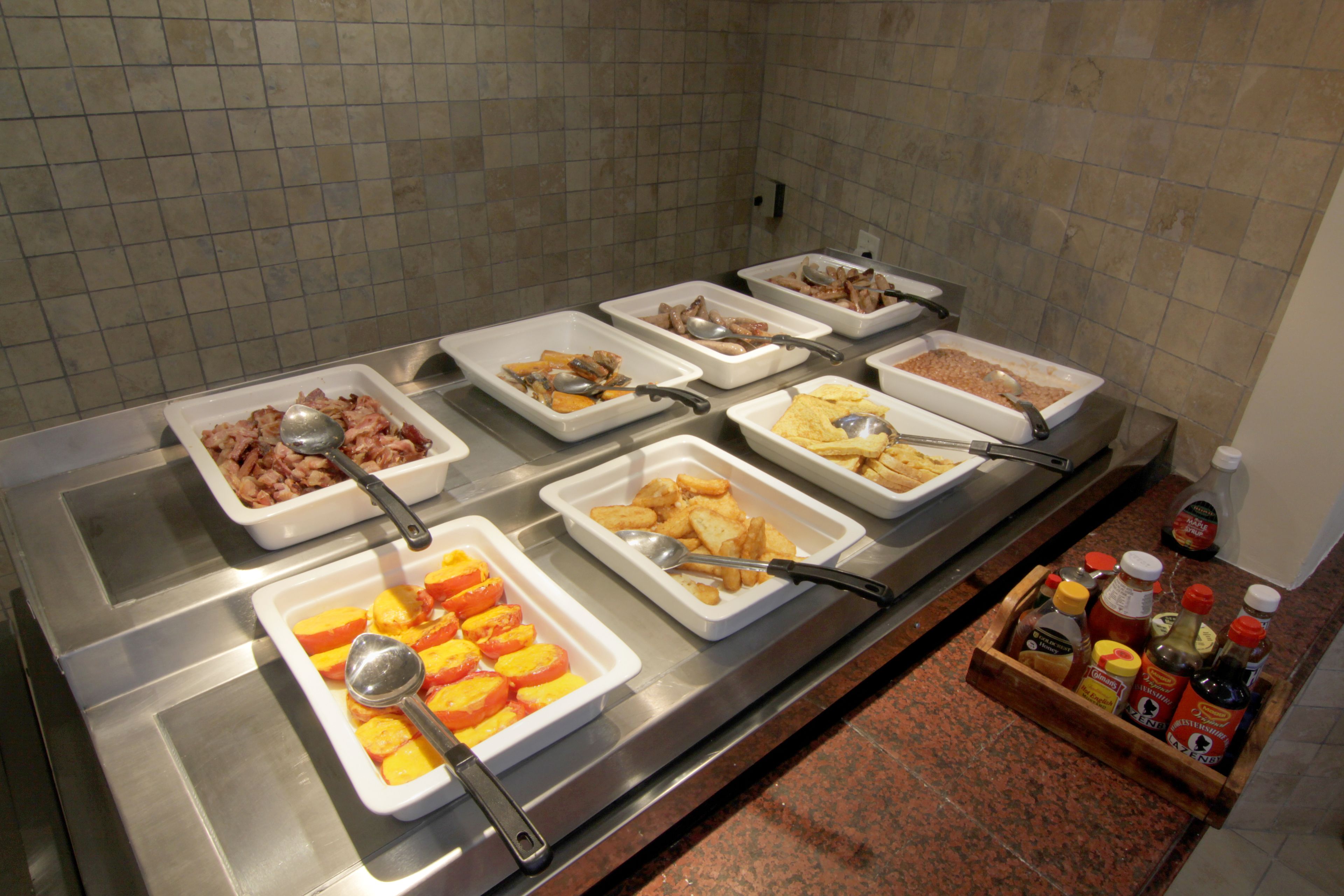 Een buffet met verschillende gerechten en bijbehorende sauzen.
