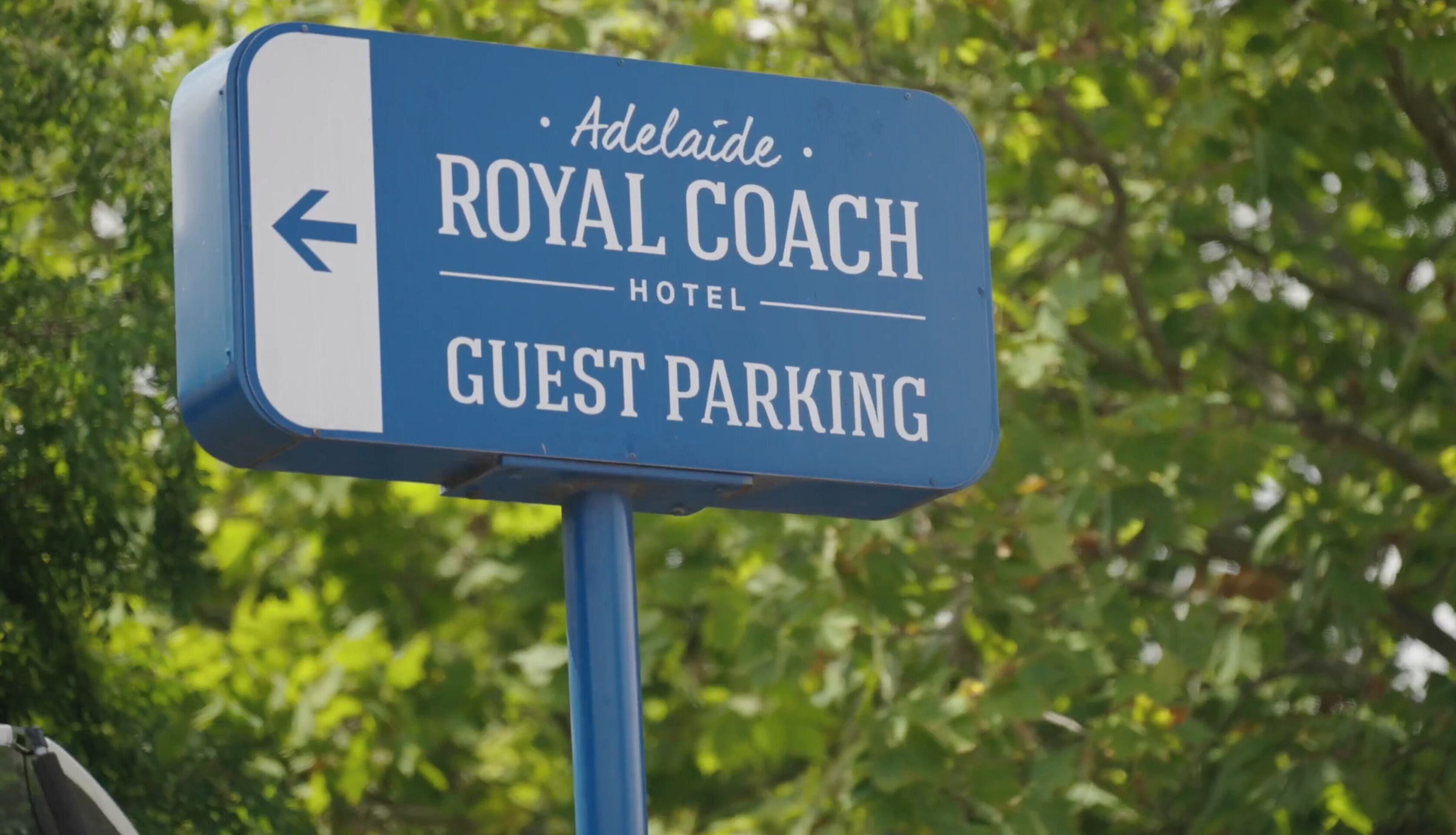 Señal del Hotel Royal Coach que indica estacionamiento para huéspedes.