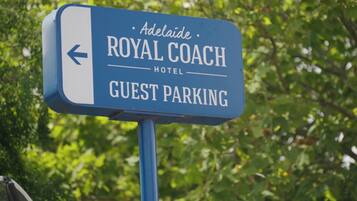 Señal del Hotel Royal Coach que indica estacionamiento para huéspedes.