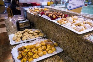 Un bufé con diversos pasteles y productos de panadería.