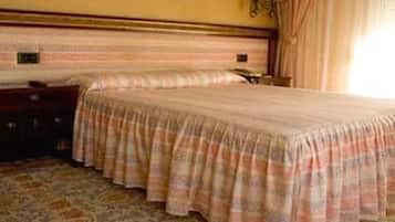 Une chambre d’hôtel avec un grand lit, une table de chevet, une lampe et un tableau encadré au mur.