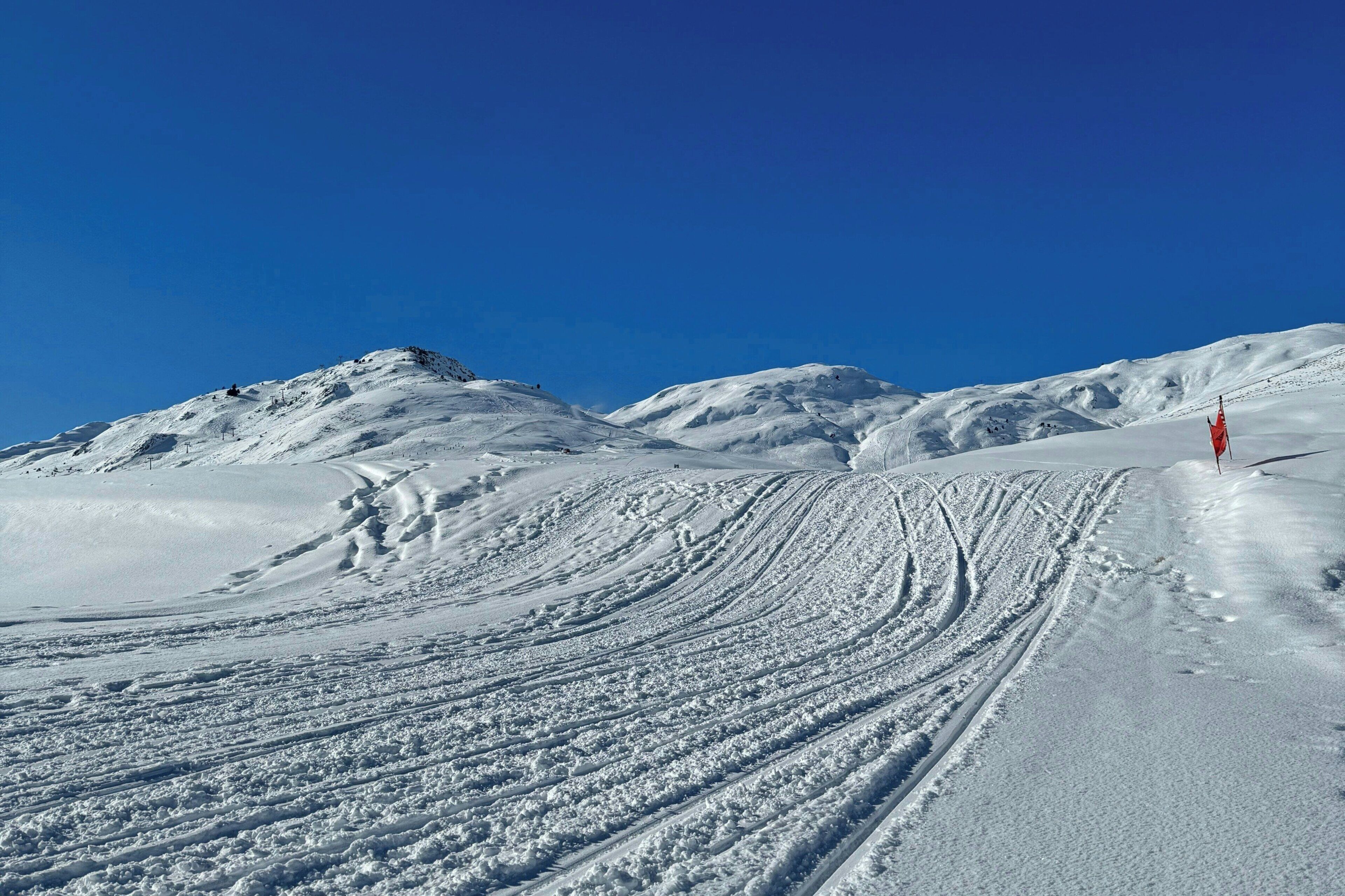 Un paisaje montañoso nevado con cielo despejado.