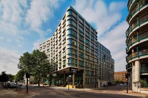 Ein modernes Hotel mit geschwungener Fassade, großen Fenstern und einem markanten Eingang.