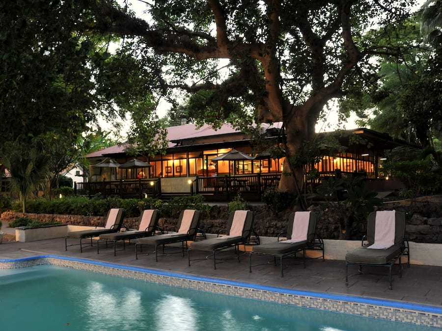 Una piscina al aire libre, sillones reclinables de piscina