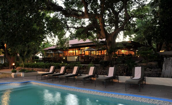 Alberca al aire libre y camastros