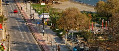 Una carretera costera con una playa y un paisaje urbano al fondo.