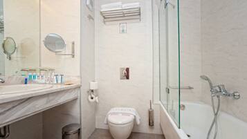 Une salle de bain moderne avec un lavabo en marbre, une douche à parois de verre et des toilettes sur lesquelles est posée une serviette.