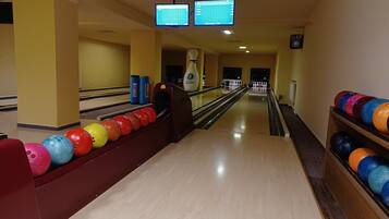 A bowling alley with lanes, bowling balls, and a bowling machine.