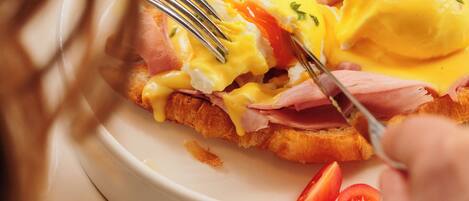 A plate of food with eggs, ham, and tomatoes.