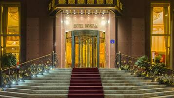 Experience the grandeur of Hotel Moskva's elegant entrance, featuring a prominent sign, marble steps, and intricate detailing.