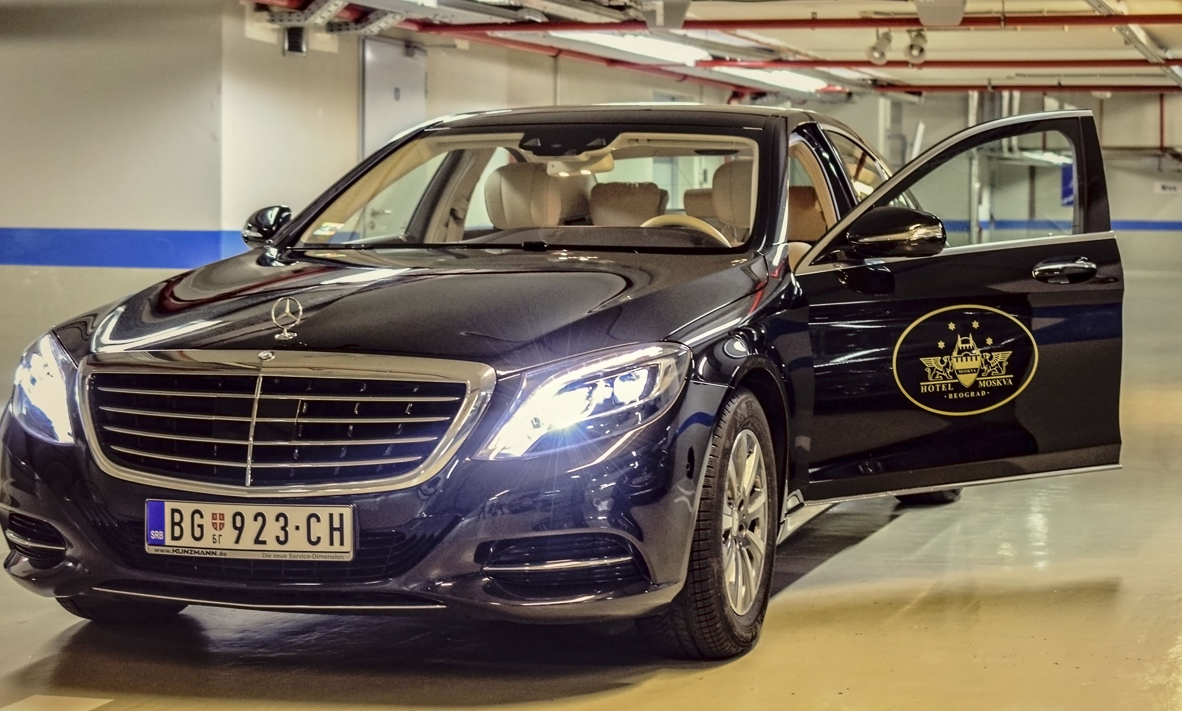 A black Mercedes-Benz with a visible license plate and a logo on the side door.