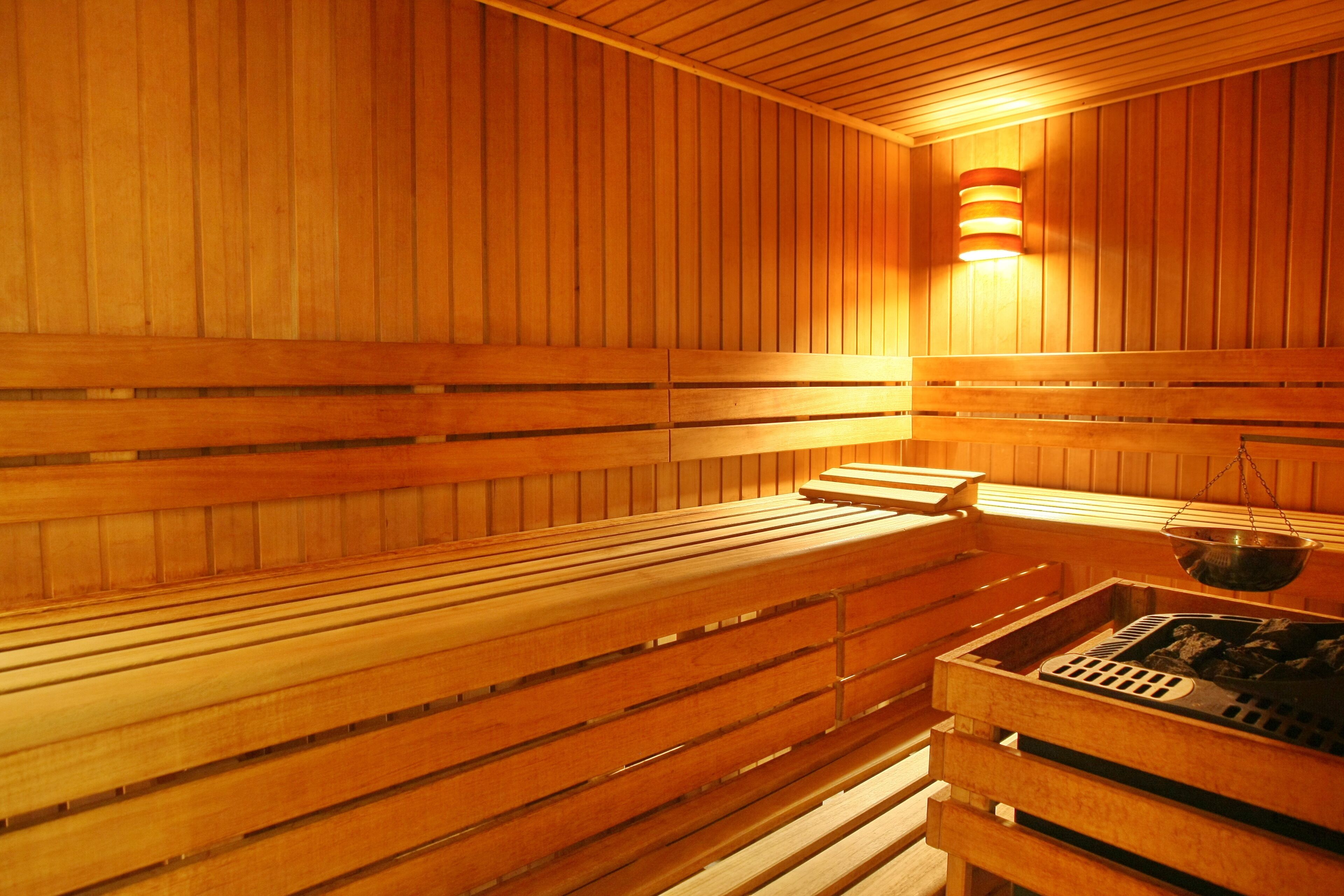 A sauna with wooden benches and a stone heating element.