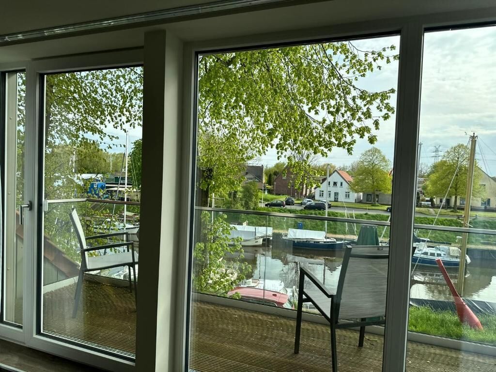 A balcony with a view of a canal, boats, and houses.