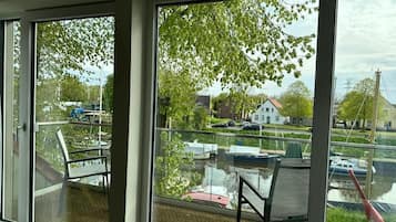 A balcony with a view of a canal, boats, and houses.