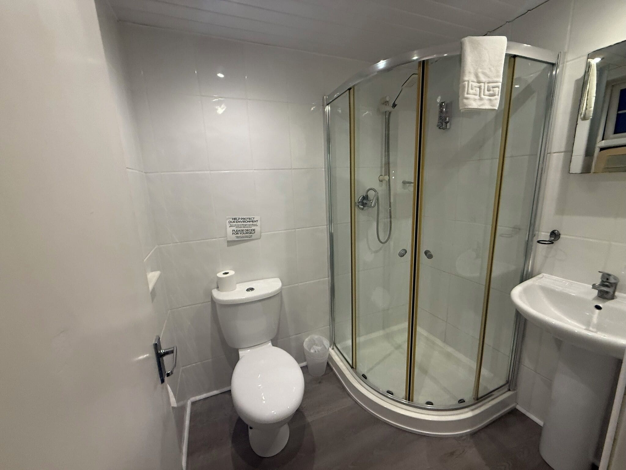 Une salle de bain moderne avec une douche à parois de verre, des toilettes et un lavabo.