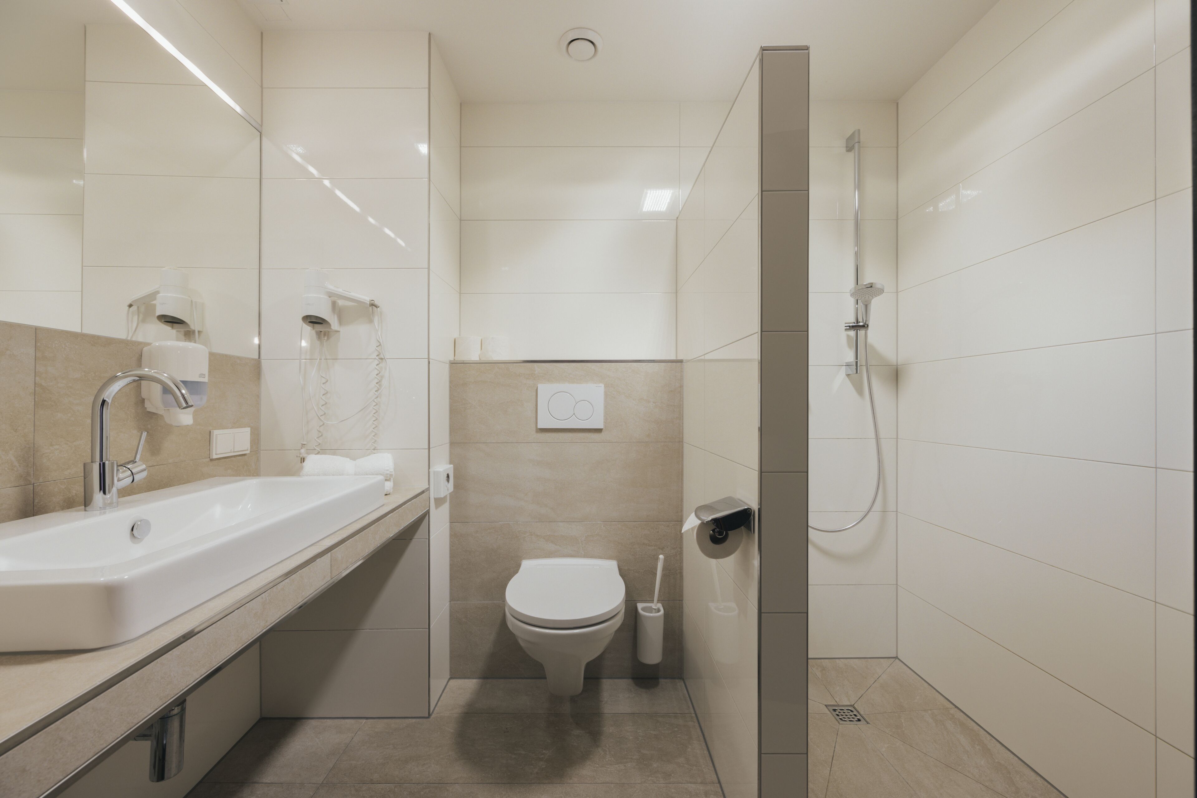 Ein modernes Badezimmer mit Waschbecken, Toilette und Dusche.