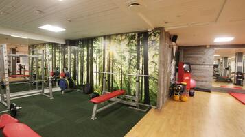 A gym with weightlifting equipment, a bench, and a mirror.
