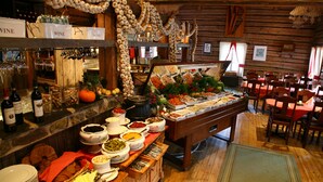 A buffet setup with various food items and wine bottles. - Hotel Hullu Poro (Kittila)