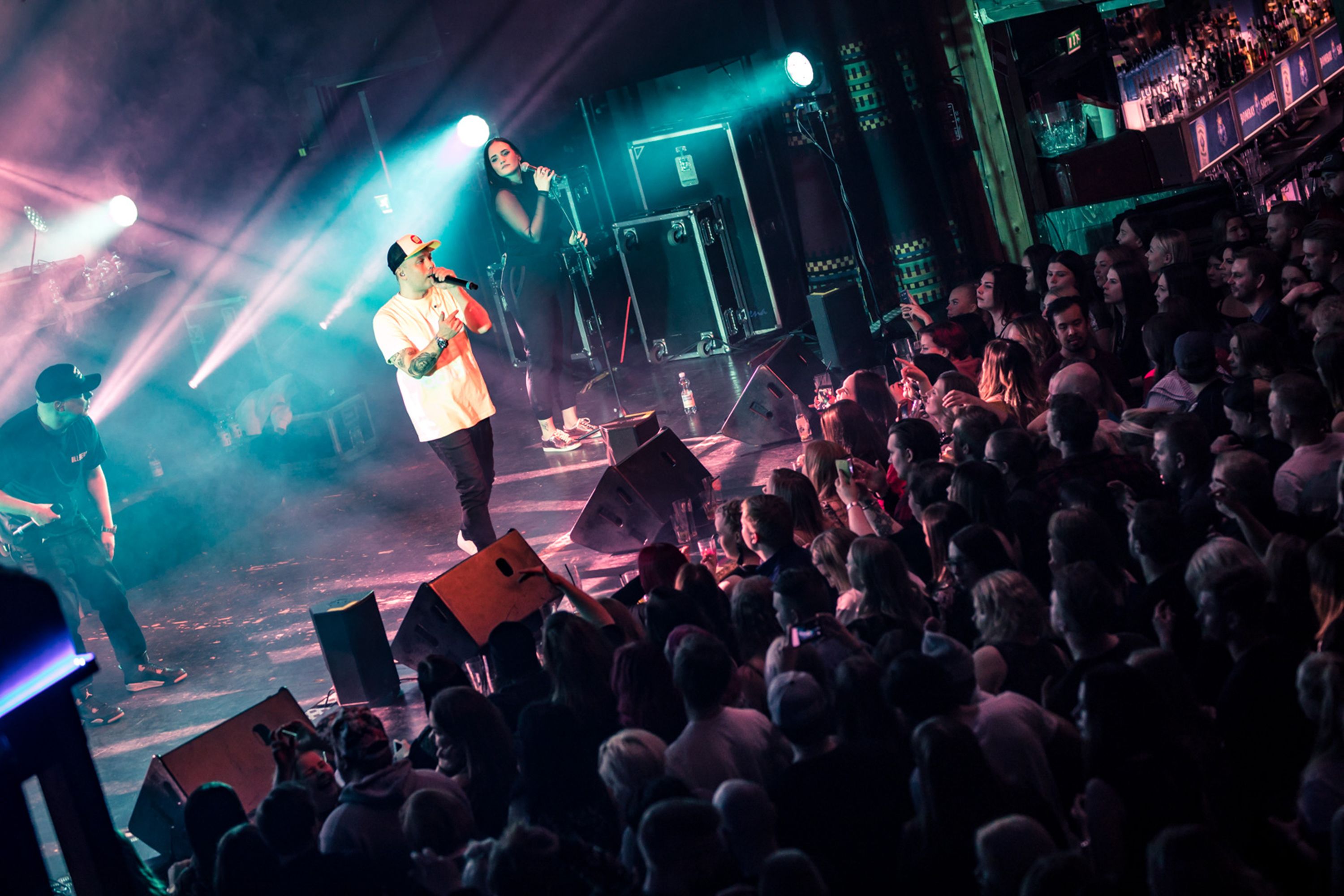 A concert with a stage, audience, and bar area.