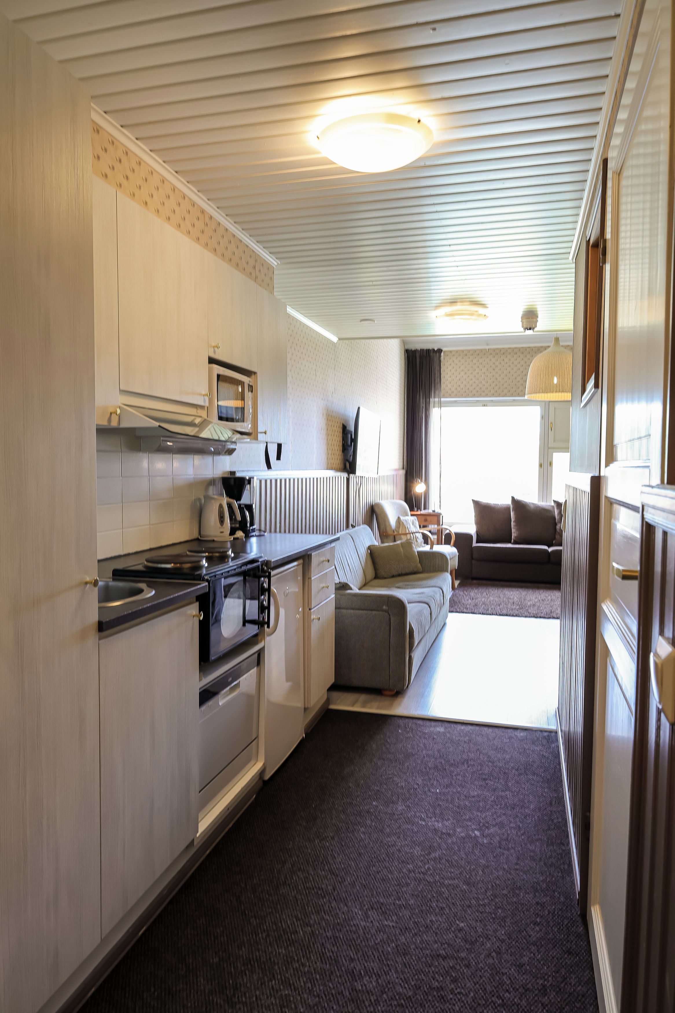 A compact kitchen with a built-in oven, microwave, and a small dining area.