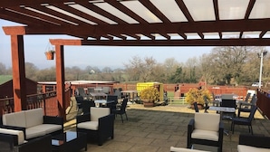 An outdoor patio area with wicker furniture and a pergola structure. - Hunters Lodge Inn (Wincanton)
