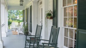 A porch with white columns, green shutters, and a bench. - The Neighbour House B&B (Long Valley)