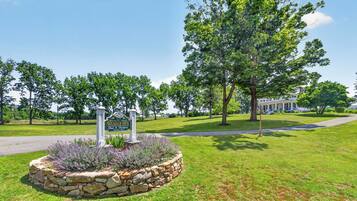 A well-maintained lawn with a stone border and a sign for a bed and breakfast.