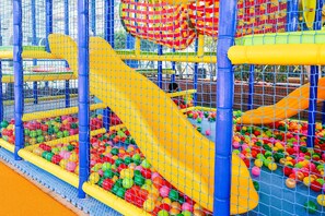 Un área de juegos infantiles con piscina de bolas y toboganes.
