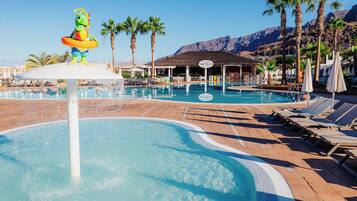 Relax by the pool surrounded by lush palm trees and a majestic mountain view.
