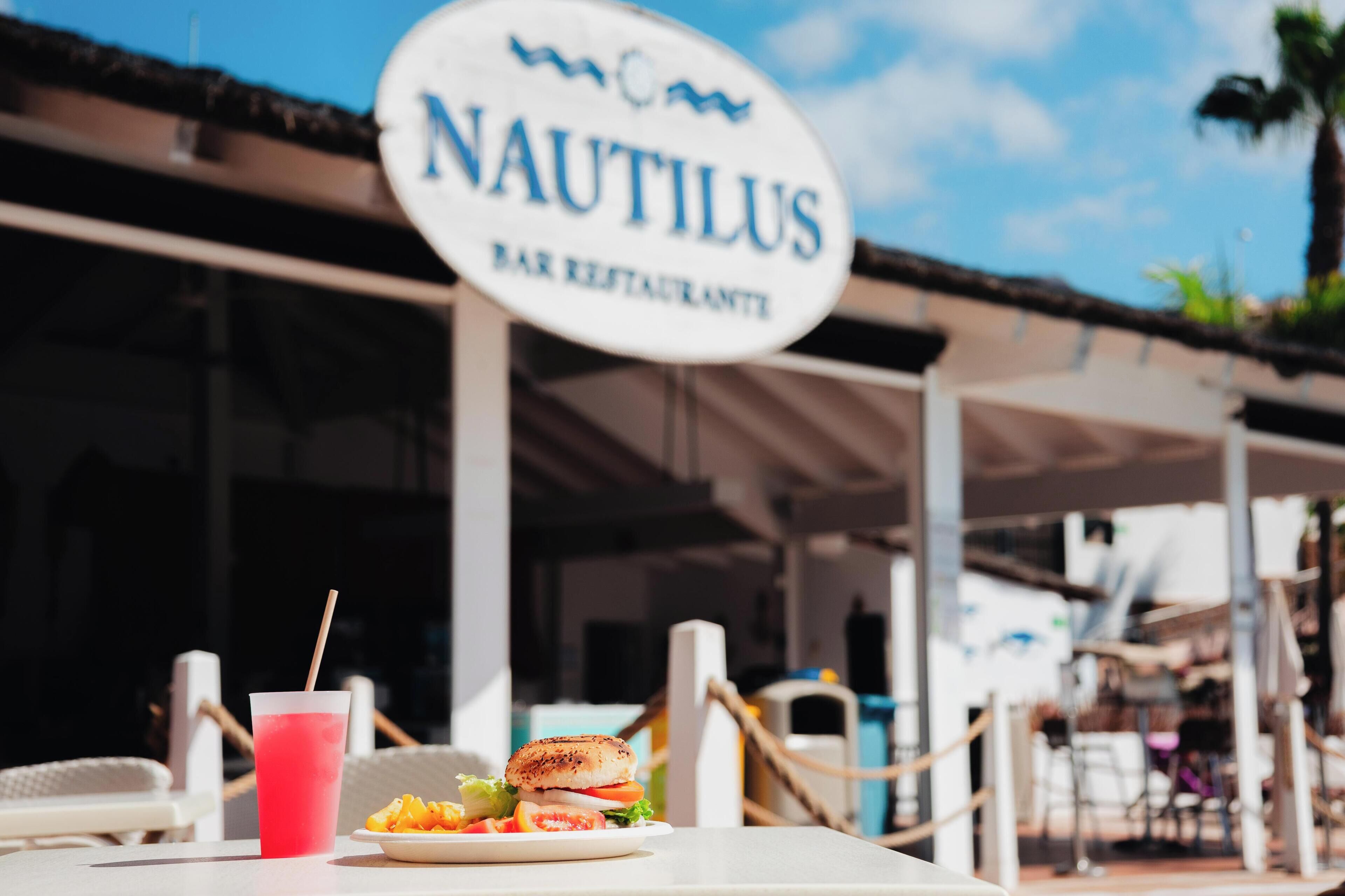 A restaurant sign with the name 'NAUTILUS' and a menu board.