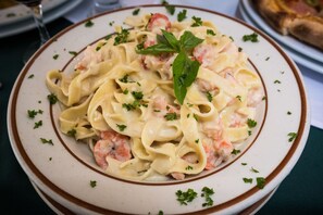 A plate of pasta with shrimp and a basil leaf garnish. - Hotel Benidorm Panama (Panama City)
