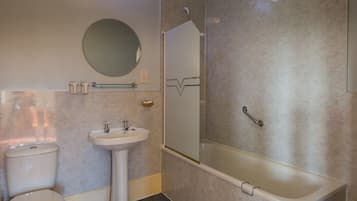 Un baño con inodoro, lavamanos y cabina de ducha.