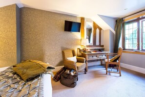 A hotel room with a bed, a desk, two chairs, a television, and a window with curtains. - Knockderry Country House Hotel (Helensburgh)