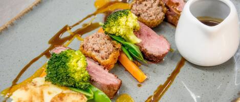 A plate of food with meat, vegetables, and sauce.