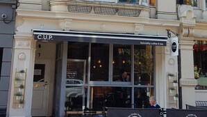 Un bâtiment sur lequel on peut lire l’inscription : « C.U.P. : café et thé de spécialité ».