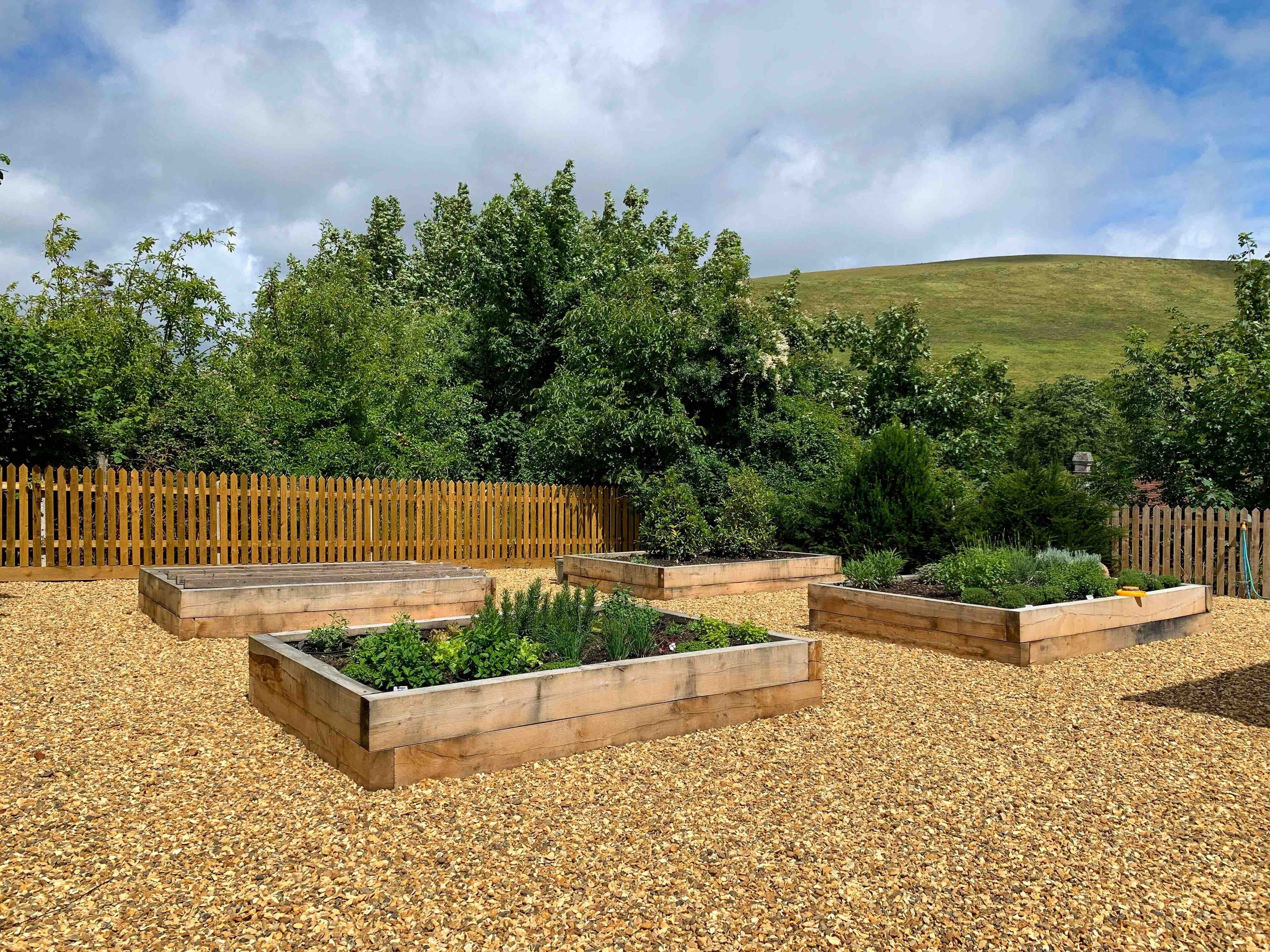 A garden with raised wooden planters and a wooden fence.