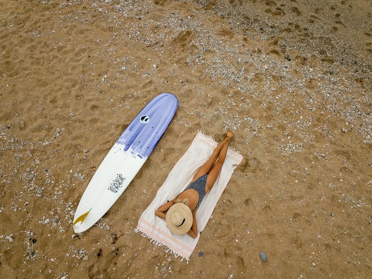 A beach scene with a surfboard and a towel.
