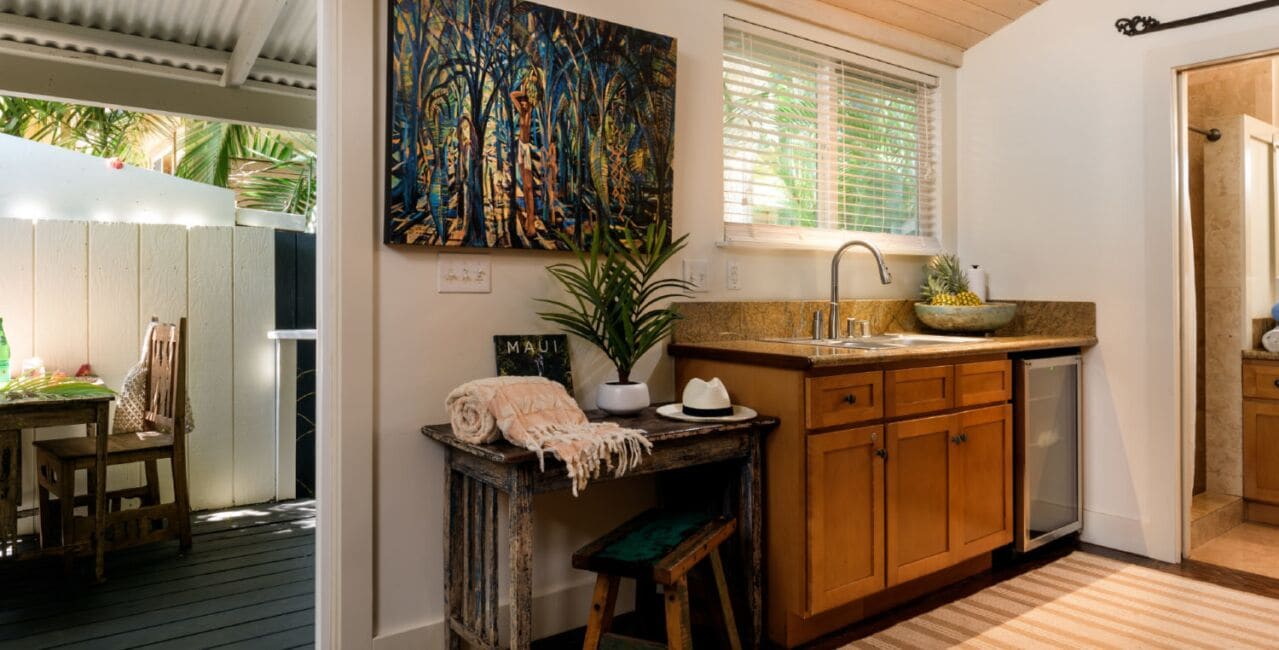 A compact kitchen with wooden cabinets, a sink, and a window with blinds.