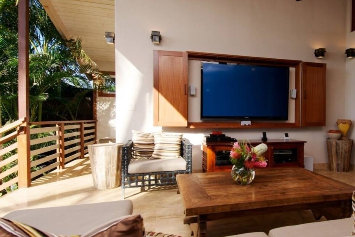 Ein Wohnzimmer mit Couch, Flachbildfernseher und Couchtisch aus Holz.