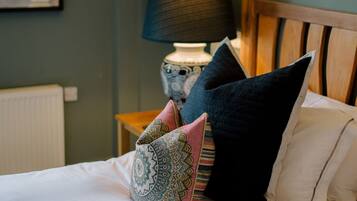A neatly made bed with patterned pillows and a bedside lamp.