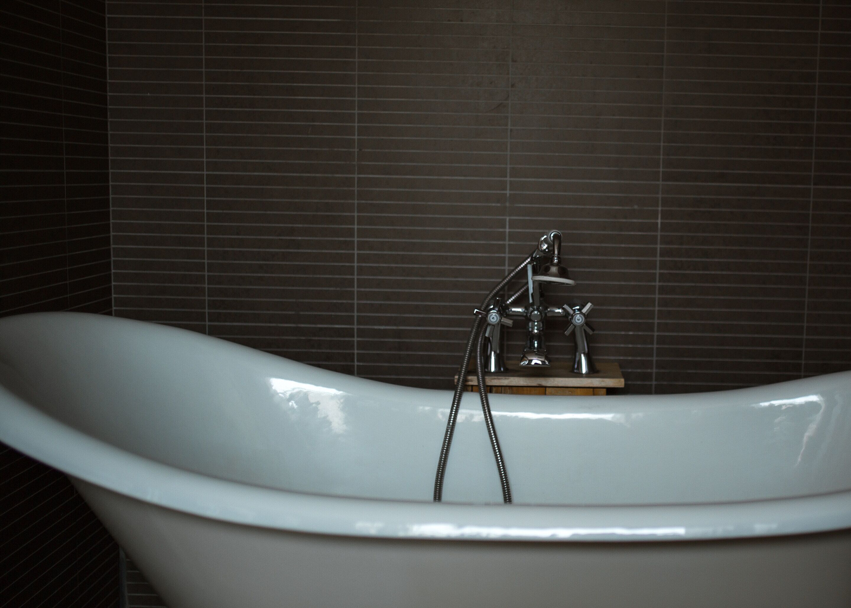 A bathtub with a modern faucet and a handheld showerhead.