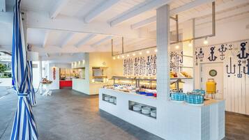 Zona de buffet con mostrador, platos y dispensadores de agua.