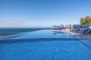 Una piscina al aire libre, sombrillas, tumbonas