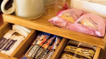 A drawer with Nescafé Original instant coffee, instant hot chocolate, and chocolate biscuits.