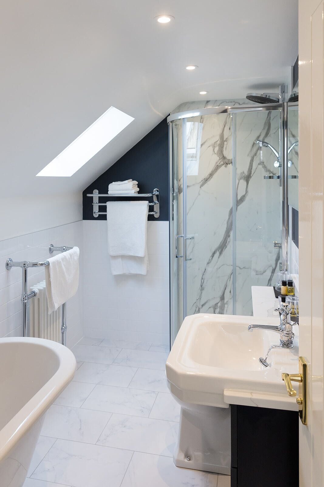A modern bathroom with a glass-enclosed shower, a freestanding bathtub, and a vanity with a mirror.