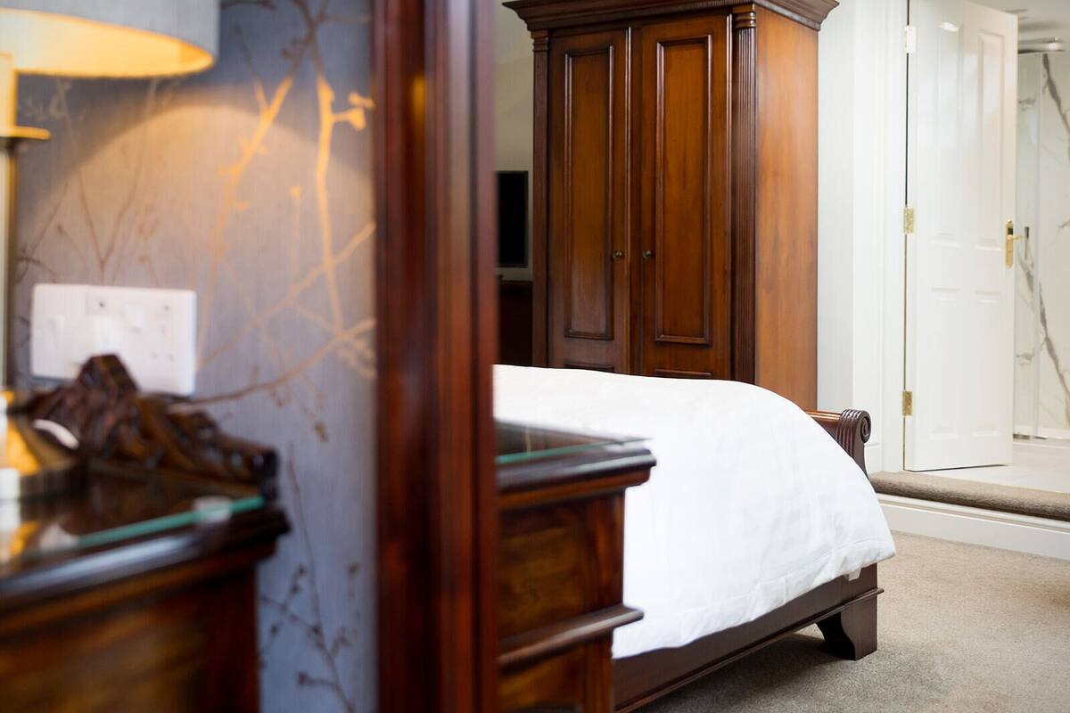 Una camera da letto con un letto in legno, un comodino e una lampada.