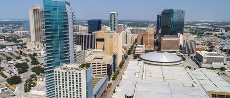 A high-rise hotel with a modern glass facade, a parking garage, and a large circular building with a dome roof.
