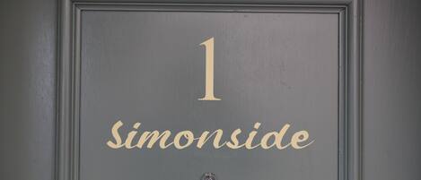 Una puerta con el número 1 y el nombre 'Simonside' en letras doradas.
