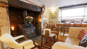 A cozy living room with a fireplace, comfortable seating, and a dining area.