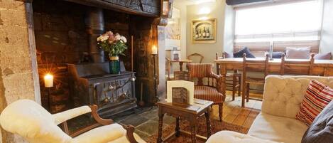 A cozy living room with a fireplace, comfortable seating, and a dining area.